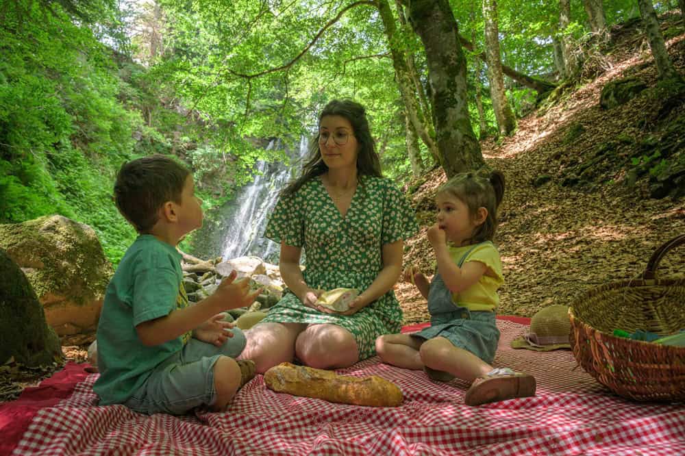 Famille profitant d'un pique-nique en forêt automnale.