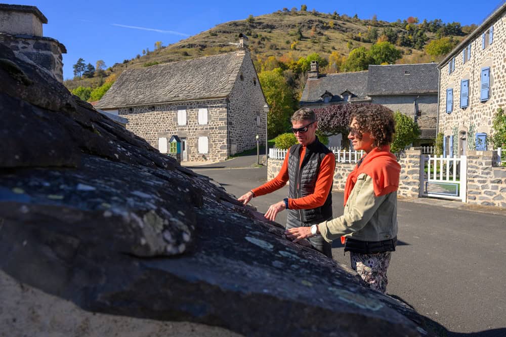 Deux personnes explorant un village de montagne en automne dans les Hautes Terres.