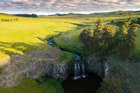 Paysage naturel avec cascade et prairies verdoyantes en Hautes Terres.