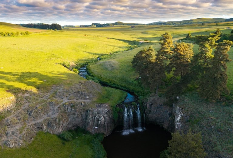 Paysage naturel avec cascade et prairies verdoyantes en Hautes Terres.