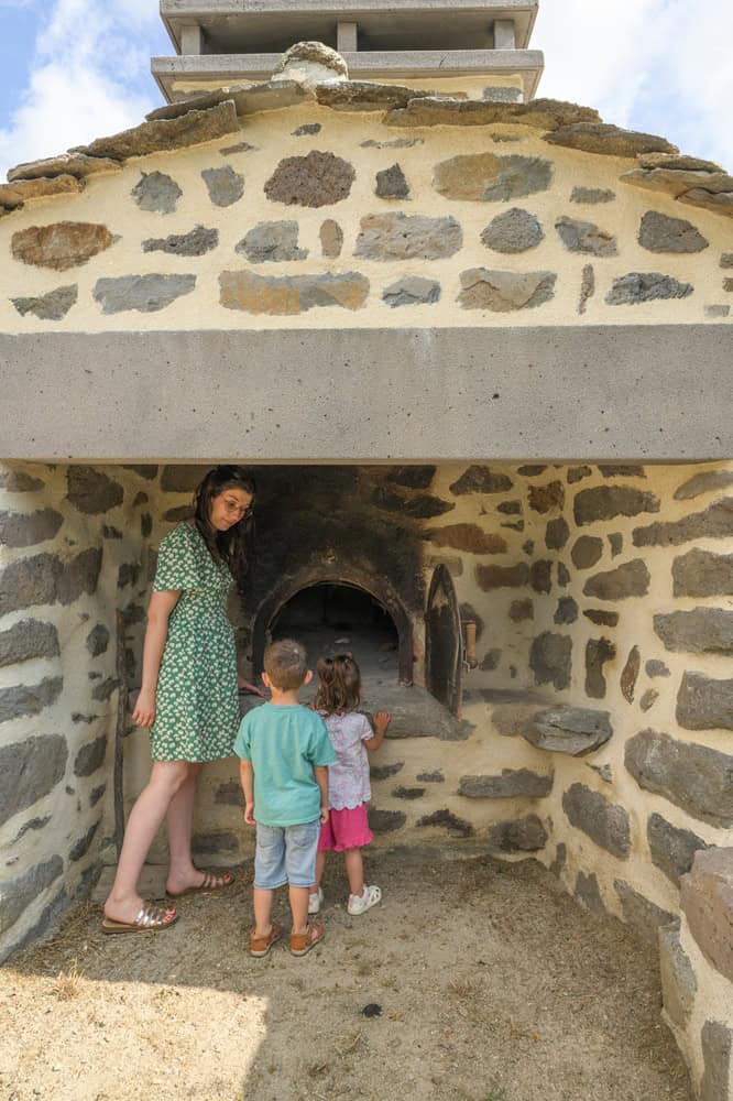 Famille devant un four à pizza en pierre dans les Hautes Terres.
