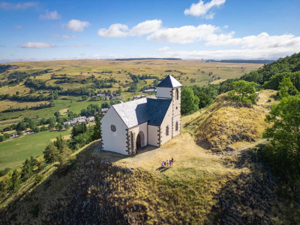 Église romane perchée dans un paysage verdoyant des Hautes Terres.