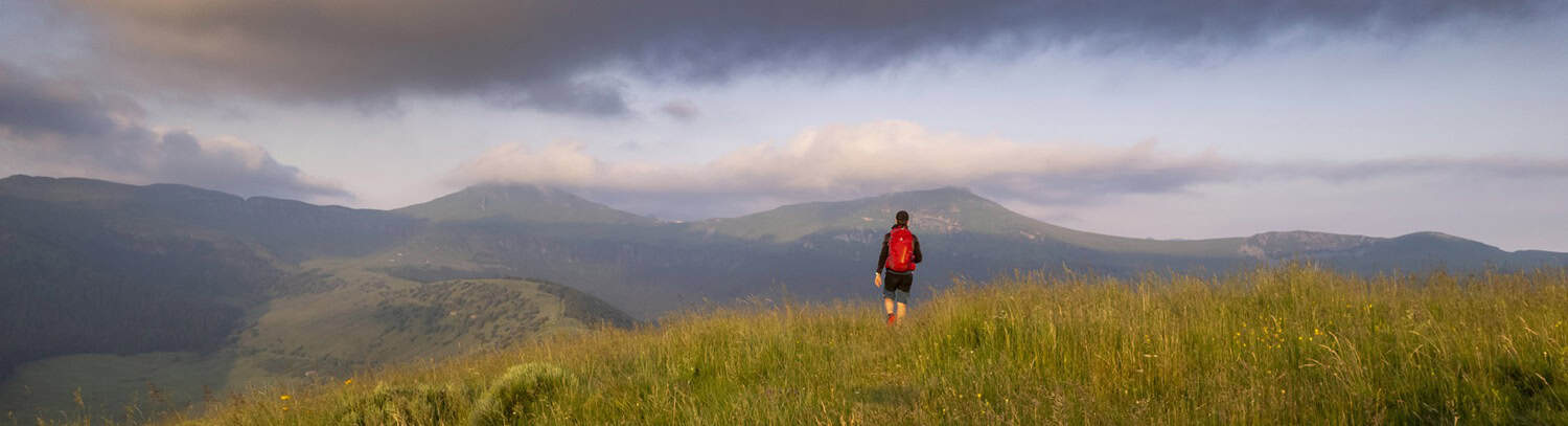 Randonneur avec sac à dos admirant le paysage des Hautes Terres.
